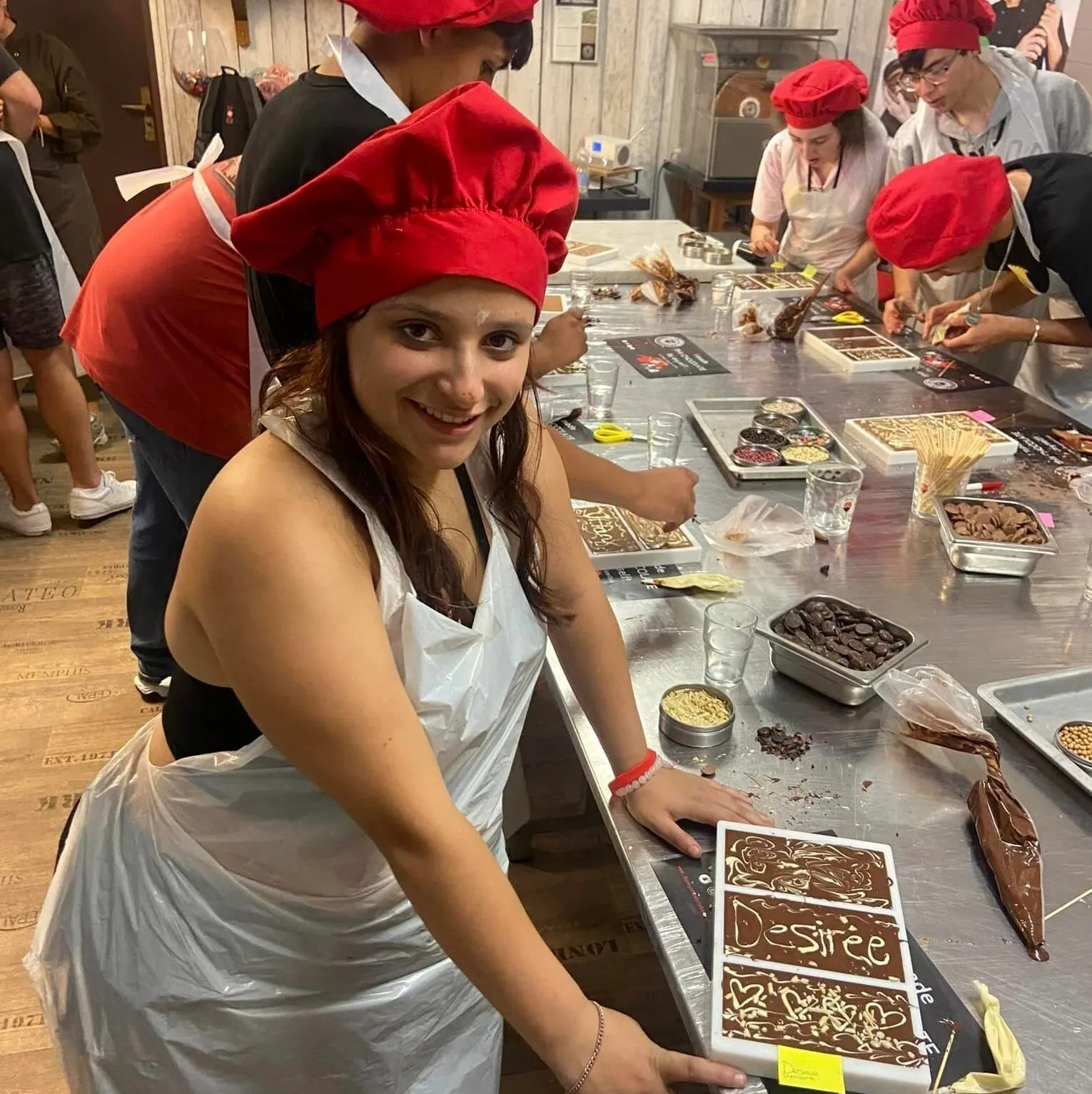 A woman in white apron holding onto some cake.