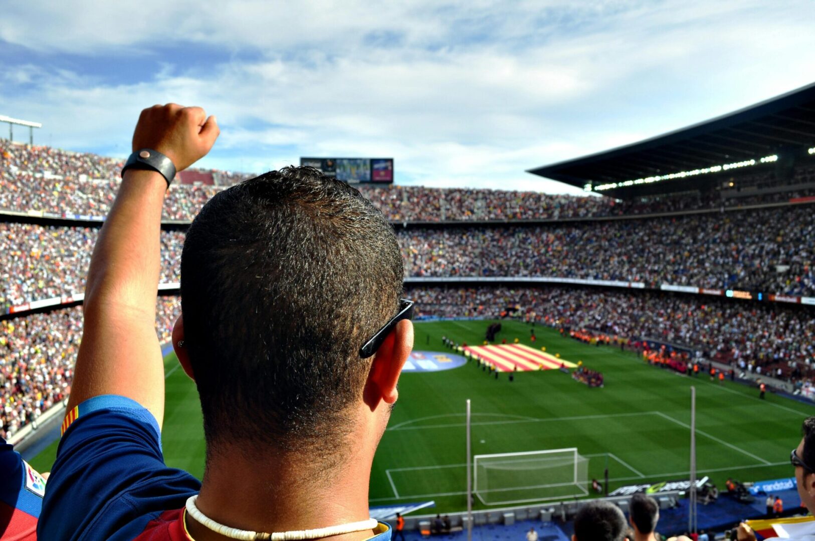 A man is raising his arm in the air at a soccer game.